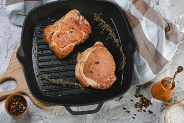Raw pork meat with spices on table. Dark black background with copy text area. Food concept
