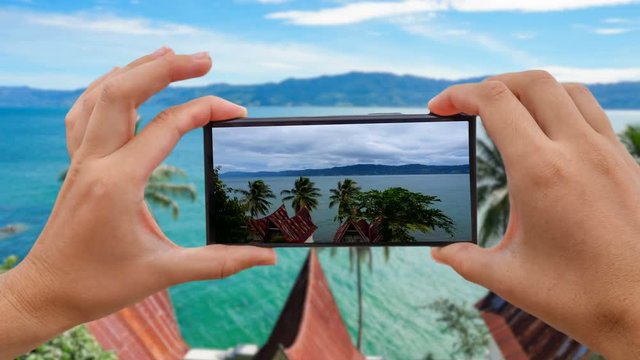 Cinemagraph of Taking Mobile Photo of Toba Lake from Samosir Island, North Sumatra, Indonesia
