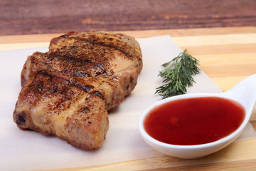grilled pork chop with Cranberry sauce on plate on wooden board