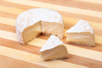 Cheese with white mold. Camembert or brie type on wood table. Healthy breakfast.