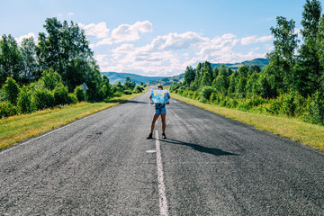 Obraz premium A girl with a map is staying on the road