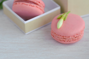 Close up of Pink raspberry macarons in the gift box on wooden background. French dessert macaroons  for best present or surprise.