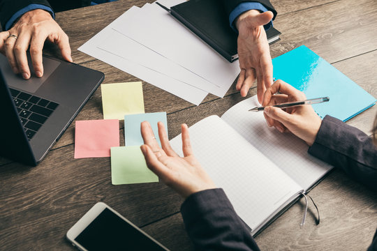 discussion, working strategy of business development. Male and female hands in suit view from above at office desk in office. Notebooks - Powered by Adobe
