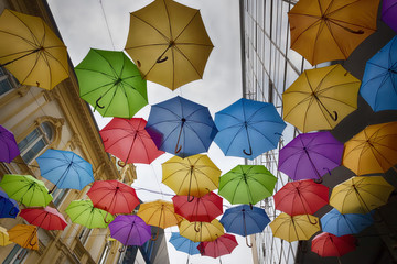 Colored umbrellas hanging between buildings