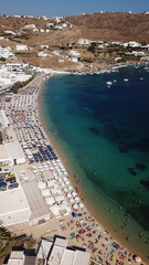 Fototapeta premium Aerial drone bird's eye view photo of famous organized with sun beds crystal clear water beach of Ornos in island of Mykonos, Cyclades, Greece