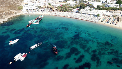 Aerial drone, bird's eye view photo of yachts docked in paradise beach of Psarou with popular pool luxury resorts, Mykonos island, Cyclades, Greece