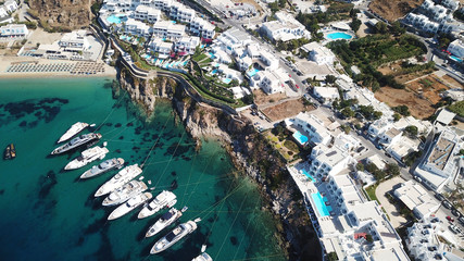 Aerial drone photo of luxury speed boats docked in popular beach of Psarou with iconic resorts, Mykonos island, Cyclades
