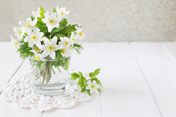 Bouquet of white spring flowers in a glass
