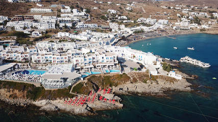 Aerial drone photo of famous pool resorts on top of rocky emerald seascape in iconic island of Mykonos, Psarou beach near Platy Gialos, Cyclades, Greece