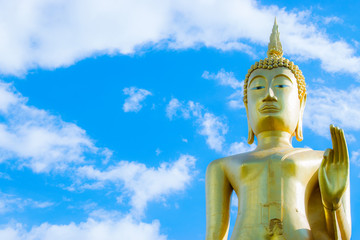 Fototapeta premium Big golden Buddha statue with blue sky background.