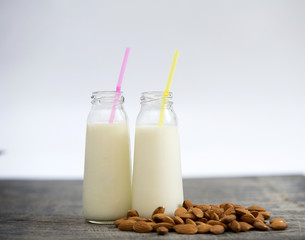 Almond milk in small bottles and almonds