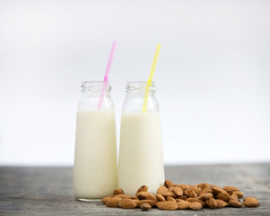 Almond milk in small bottles and almonds