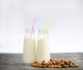Almond milk in small bottles and almonds