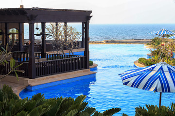 View of terrace lounge bar, restaurant, swimming pool, beach and ocean.