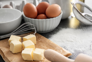 Fototapeta na wymiar Cut butter, whisk and eggs on kitchen table. Bakery workshop