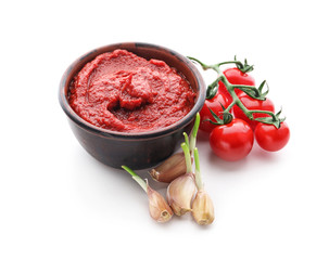 Bowl of delicious tomato sauce with garlic on white background