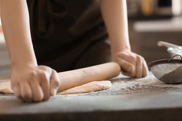 Obraz na płótnie Canvas Baker rolling dough on kitchen table