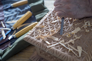 carpenter's hands carving a wooden box