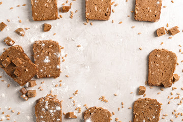 Flat lay composition with slices of freshly baked rye bread on gray background