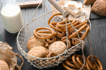 Metal basket with different bakery products on table