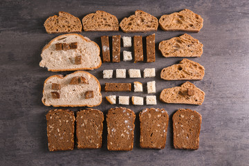 Flat lay composition with slices of freshly baked bread on gray background