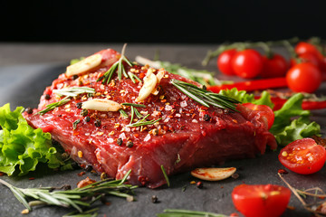 Raw meat with spices and vegetables on table