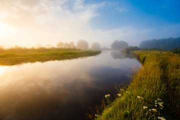 River curve at sunrise landscape. Thick fog over the river in the countryside