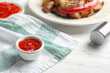 Bowl with barbecue sauce on table