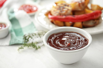 Bowl with barbecue sauce on table