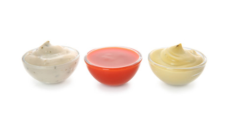 Bowls with different sauces on white background