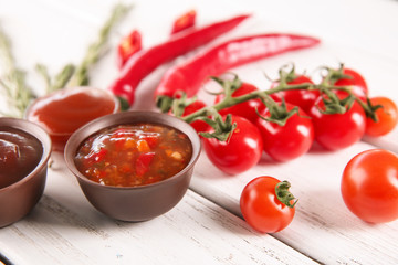 Bowls with different sauces and ingredients on table, closeup