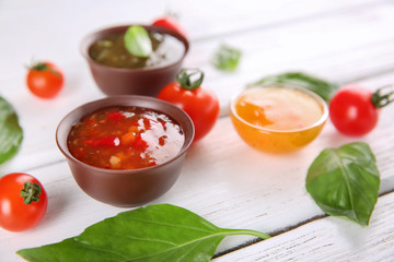 Bowls with different sauces and ingredients on table, closeup