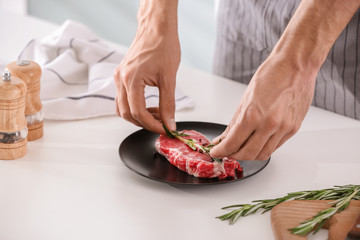 Obraz na płótnie Canvas Man preparing meat in kitchen