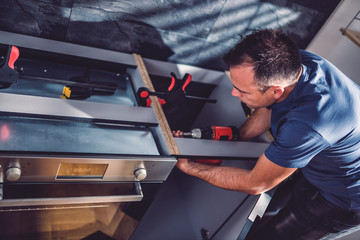 Man building kitchen and using a cordless drill