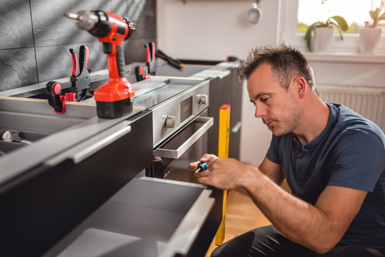Men building kitchen cabinet