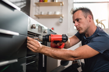 Man building kitchen and using a cordless drill
