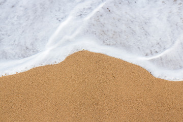 Fototapeta na wymiar summer background - top view of sandy beach and sea water