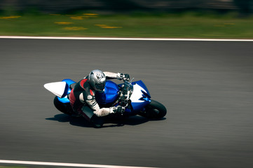 Road racing motorcycle going fast into corner