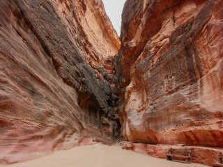 Great high reddish-orange rock mountains of ancient city Petra, Jordan, outdoor, sunny day.