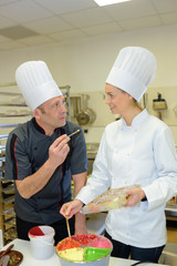 female and male chefs decorating pastries