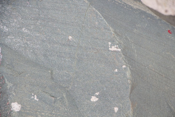 The surface of an old rock with cracks. Old rock texture (wild background)