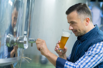 man looking at dark craft beer