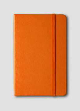 Orange closed notebook isolated on grey