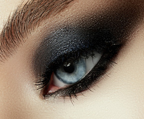 Close up view of young beautiful woman. Perfect skin and evening makeup. Silver smokey eyes. Macro studio shot. Sensuality, passion, cosmetology and modern makeup concept. © looking2thesky