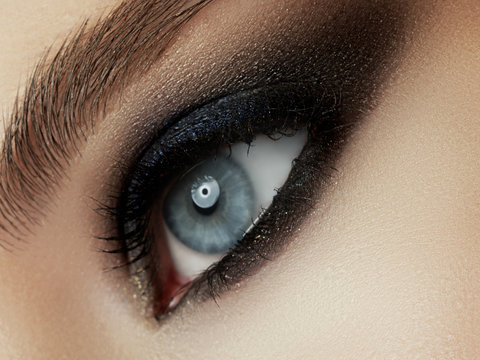 Close up view of young beautiful woman. Perfect skin and evening makeup. Silver smokey eyes. Macro studio shot. Sensuality, passion, cosmetology and modern makeup concept.