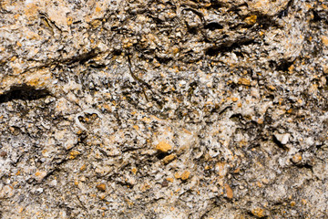 The surface of an old rock with cracks. Old rock texture (wild background)