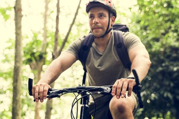 Happy cyclist riding through the forest