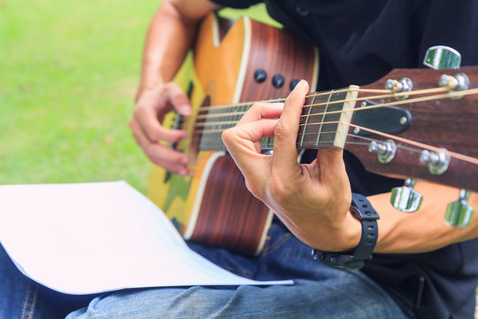 Musician playing guitar in the park