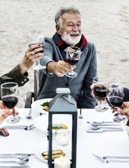 Seniors toasting with red wine at the beach