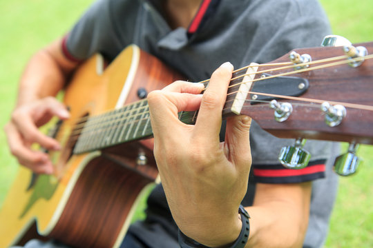Musician playing guitar in the park